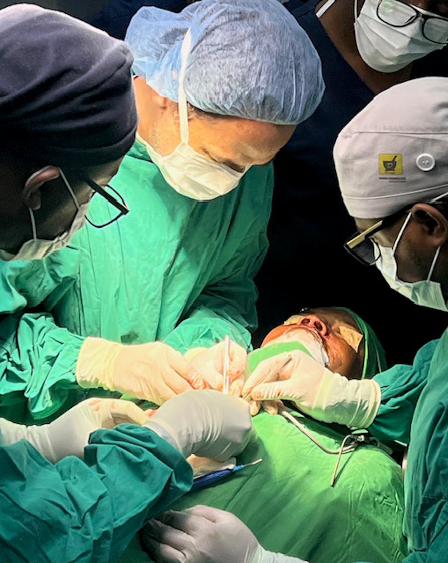 Doctors performing surgery around patient